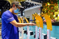 Anh Phạm Đức Dương, thành viên Ban sáng lập Câu lạc bộ Weekend đang kiểm tra máy xịt sát khuẩn “không chạm” để đưa đi trao tặng cho lực lượng phòng, chống dịch tại Đà Nẵng. (Ảnh: Trần Lê Lâm/TTXVN)