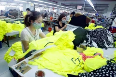 Công nhân sản xuất sản phẩm may mặc. (Ảnh: Phạm Kiên/TTXVN)