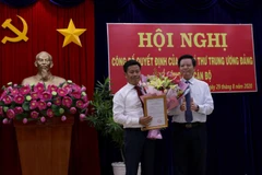 Ông Mai Văn Chính, Ủy viên Trung ương Đảng, Phó trưởng Ban Tổ chức Trung ương trao Quyết định của ban Bí thư cho ông Lê Quân. (Ảnh: Kim Há/TTXVN)