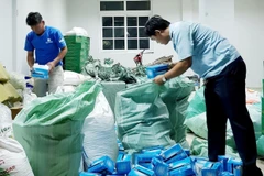 Cán bộ hải quan Chi cục Hải quan cửa khẩu quốc tế Vĩnh Xương, tỉnh An Giang, kiểm đếm số khẩu trang y tế mới thu giữ. (Ảnh: Công Mạo/TTXVN)