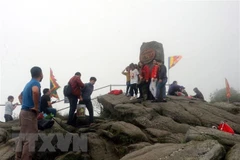 Du khách chụp ảnh lưu niệm trên đỉnh thiêng Yên Tử. (Ảnh: Đức Hiếu/TTXVN)