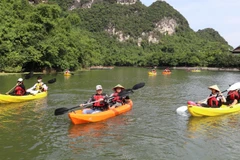 Du khách trải nghiệm mới tại Tràng An. (Ảnh: Đức Phương/TTXVN)