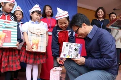 Phó Thủ tướng Vũ Đức Đam tặng sách cho học sinh Trường Tiểu học Dạ Trạch, xã Dạ Trạch, huyện Khoái Châu, tỉnh Hưng Yên. (Ảnh: Đinh Tuấn/TTXVN)
