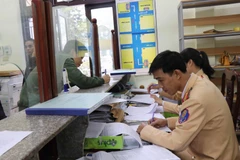  Lái xe đến nộp “phạt nguội” vi phạm giao thông tại Phòng Cảnh sát giao thông. (Ảnh: Thanh Thương/TTXVN)