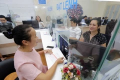 Khách hàng giao dịch. (Ảnh minh họa: Trần Việt/TTXVN)