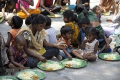 Người vô gia cư nhận thức ăn từ một chương trình cứu trợ dành cho người nghèo ở Hyderabad, Ấn Độ năm 2019. (Ảnh: AFP/TTXVN)