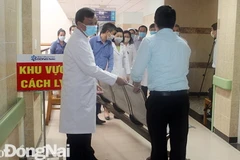 Lãnh đạo Bệnh viện đa khoa Đồng Nai gỡ bỏ bảng cách ly, phong tỏa đối với Khoa Ung bướu. (Nguồn: baodongnai)