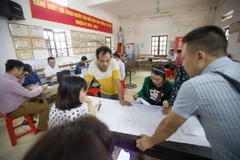 Cán bộ ngành Tài nguyên và Môi trường làm thủ tục cho người dân trong quy trình kiểm kê đất đai và lập bản đồ hiện trạng sử dụng đất. (Ảnh: Trọng Đạt/TTXVN)