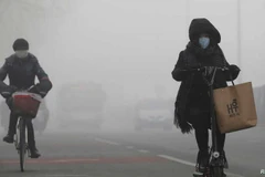 Mọi người đi xe giữa sương khói ở Bắc Kinh của Trung Quốc. (Nguồn: Reuters)