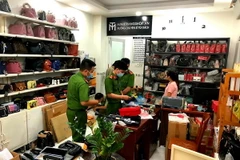 Lực lượng chức năng kiểm tra cửa hàng kinh doanh túi xách bắt giữ lô công cụ hỗ trợ cực lớn. (Ảnh: TTXVN phát)