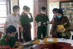 Lực lượng chức năng kiểm tra bưu phẩm chứa các linh kiện lắp ráp súng hơi. (Ảnh: Đồng Thúy/TTXVN)