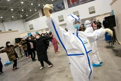 Các bệnh nhân tham gia tập thể dục dưới sự hướng dẫn của nhân viên y tế tại bệnh viện dã chiến ở Vũ Hán, tỉnh Hồ Bắc, Trung Quốc, ngày 12/2 vừa qua. (Ảnh: THX/TTXVN)