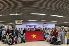 Công dân Việt Nam tại Bangladesh chuẩn bị làm thủ tục lên máy bay về nước. (Ảnh: TTXVN phát)