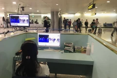 Nhân viên sân bay kiểm tra màn hình hiển thị máy quét thân nhiệt đối với hành khách quốc tế đến Việt Nam. (Ảnh: Đinh Hằng/TTXVN)