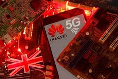 Cờ Anh và điện thoại thông minh có logo mạng Huawei và 5G. (Nguồn: Reuters)