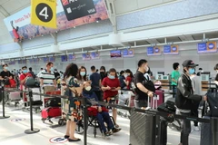 Công dân Việt Nam làm thủ tục lên máy bay về nước tại sân bay thành phố Toronto. (Ảnh: Quang Thịnh/TTXVN)