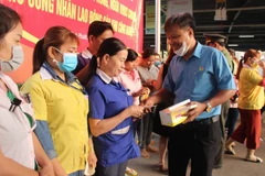 Phát khẩu trang cho công nhân tại ở tỉnh Bình Phước. (Ảnh: Dương Chí Tưởng/TTXVN)