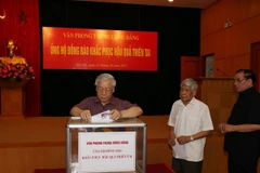 Tổng Bí thư Nguyễn Phú Trọng, nguyên Tổng Bí thư Lê Khả Phiêu và nguyên Tổng Bí thư Nông Đức Mạnh tham gia quyên góp ủng hộ đồng bào khắc phục hậu quả thiên tai. (Ảnh: Trí Dũng/TTXVN)