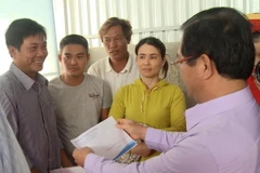 Bí thư Tỉnh ủy Quảng Ngãi Lê Viết Chữ trao tiền hỗ trợ cho ngư dân. (Ảnh: Phước Ngọc/TTXVN)