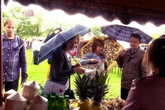 Thực khách đội mưa để thưởng thức các món ăn Việt. (Ảnh: Quang Vinh/TTXVN)