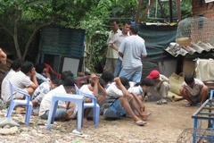 Các con bạc bị bắt quả tang tại hiện trường một trường gà. (Ảnh: Thế Vinh/TTXVN)