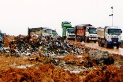 Chôn lấp rác thải ở bãi rác Nam Sơn. (Ảnh :Bùi Tường/TTXVN)