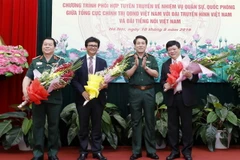 Thượng tướng Lương Cường tặng hoa chúc mừng các đơn vị tại lễ ký. (Ảnh: An Đăng/TTXVN) 