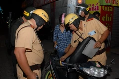 Lực lượng cảnh sát giao thông và cơ động kiểm tra phương tiện tại quận 12. (Ảnh: Mạnh Linh/TTXVN) 