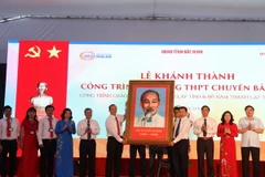Thứ trưởng Bộ Giáo dục và Đào tạo Nguyễn Vinh Hiển tặng bức ảnh chân dung Bác Hồ cho Trường THPT Chuyên Bắc Ninh nhân dịp khánh thành. (Ảnh: Thái Hùng/TTXVN)