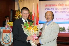 Chủ tịch Hội Hữu nghị Việt Nam-Ba Lan TP.HCM Nguyễn Đăng Cường tặng hoa chúc mừng ngài Szymon Wudarski, Phó Đại sứ Cộng hòa Ba Lan tại Việt Nam. (Ảnh: Thanh Vũ/TTXVN)