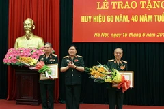 Đại tướng Ngô Xuân Lịch, Bộ trưởng Bộ Quốc phòng trao Huy hiệu 60 năm tuổi Đảng cho Đại tướng Phạm Văn Trà (bên phải); huy hiệu 40 năm tuổi Đảng cho Thượng tướng Trương Quang Khánh (trái). (Nguồn: mod.gov.vn)
