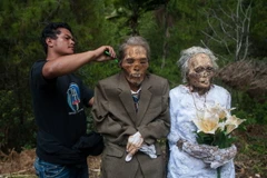 Một người cháu trai chải tóc cho ông bà đã khuất trong nghi lễ Ma'nene, diễn ra ba năm một lần. (Nguồn: Dailymail)