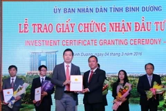Ông Trần Văn Nam, Bí thư Tỉnh ủy Bình Dương trao giấy phép cho nhà đầu tư. (Ảnh: Quách Lắm/Vietnam+)