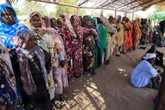 Phụ nữ Sudan chờ nhận hàng cứu trợ tại trại tị nạn dành cho những người mất nhà cửa do chiến tranh ở Nyala, Nam Darfur. (Ảnh: AFP/TTXVN)