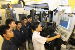 Giáo viên dạy nghề hướng dẫn học sinh thực hành. (Ảnh: Vũ Sinh/TTXVN)