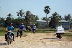 Người dân tỉnh Kiên Giang và Campuchia đi lại qua tuyến biên giới Hà Tiên. (Ảnh: Lê Sen/TTXVN)