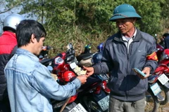 Du khách gửi xe tại khu vực tượng đài Thánh Gióng phải trả 20.000 đồng/xe máy trong ngày diễn ra lễ hội. (Ảnh: Quý Trung/TTXVN)