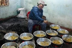 Người dân làng nghề thực hiện công đoạn rim (ngào) mứt. (Ảnh: Trịnh Bang Nhiệm/TTXVN)