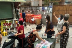 Các tổ chức, đoàn thể cung cấp nhu yếu phẩm cho người dân trong khu vực cách ly tại hẻm 637/37 Quang Trung, quận Gò Vấp, Tp.Hồ Chí Minh. (Ảnh: Anh Tuấn/TTXVN)