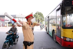 Lực lượng CSGT số 14 tổ chức phân luồng giao thông để không xảy ra ùn tắc tại khu vực Bến xe Nước Ngầm. (Ảnh: Phạm Kiên/TTXVN)