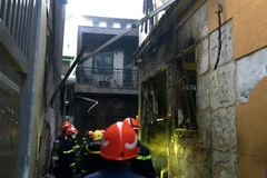 Lực lượng chức năng tại hiện trường vụ cháy. (Ảnh: TTXVN phát)