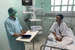 Cán bộ Đại sứ quán thăm hỏi, động viên ngư dân bị thương đang được điều trị tại bệnh viện. (Ảnh: TTXVN phát)