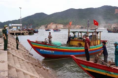 Đồn biên phòng Cửa Sót tuyên truyền bầu cử và phòng chống dịch, bệnh COVID-19 tại cảng cá Thạch Kim, huyện Lộc Hà. (Ảnh: Công Tường-TTXVN)