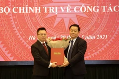 Trưởng Ban Tuyên giáo Trung ương Nguyễn Trọng Nghĩa trao Quyết định của Bộ Chính trị phân công đồng chí Lê Quốc Minh giữ chức vụ Tổng Biên tập báo Nhân dân. (Ảnh: Nguyễn Điệp/TTXVN)
