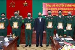Chủ tịch nước Nguyễn Xuân Phúc tặng ảnh chân dung Chủ tịch Hồ Chí Minh cho cán bộ Bộ Tư lệnh Quân khu 7. (Ảnh: Thống Nhất/TTXVN)