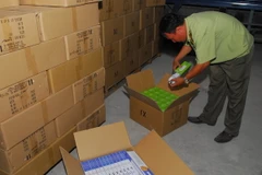 Lực lượng chức năng kiểm tra, thống kê số lượng hàng không hoá đơn, chứng từ. (Ảnh: Mạnh Linh/TTXVN)