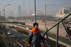 Người dân đeo khẩu trang tránh ô nhiễmkhông khí ở thủ đô Bắc Kinh ngày 2/1. (Nguồn: EPA/TTXVN)