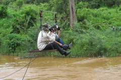 Phóng viên tác nghiệp trên cầu dây. (Ảnh: Hoài Nam/TTXVN)