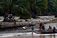 Người dân di chuyển bằng bè để qua sông sau bão Tembin tại tỉnh Lanao del Norte, Philippines ngày 23/12. (Nguồn: THX/TTXVN)