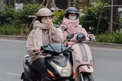 Người dân đi học, đi làm hoặc di chuyển ngoài trời phải trang bị thêm nhiều đồ giữ ấm cơ thể. (Ảnh: Hoàng Hiếu/TTXVN)